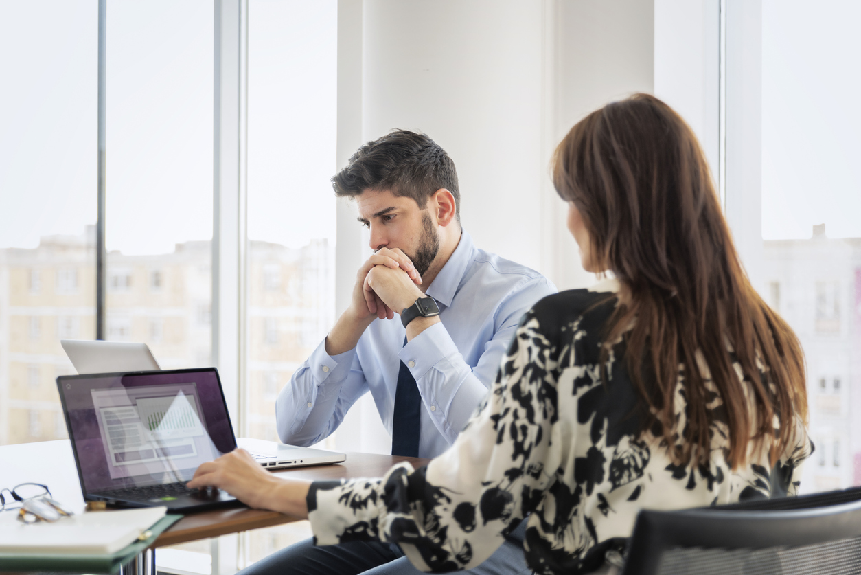 Man and woman looking at financial information on laptop